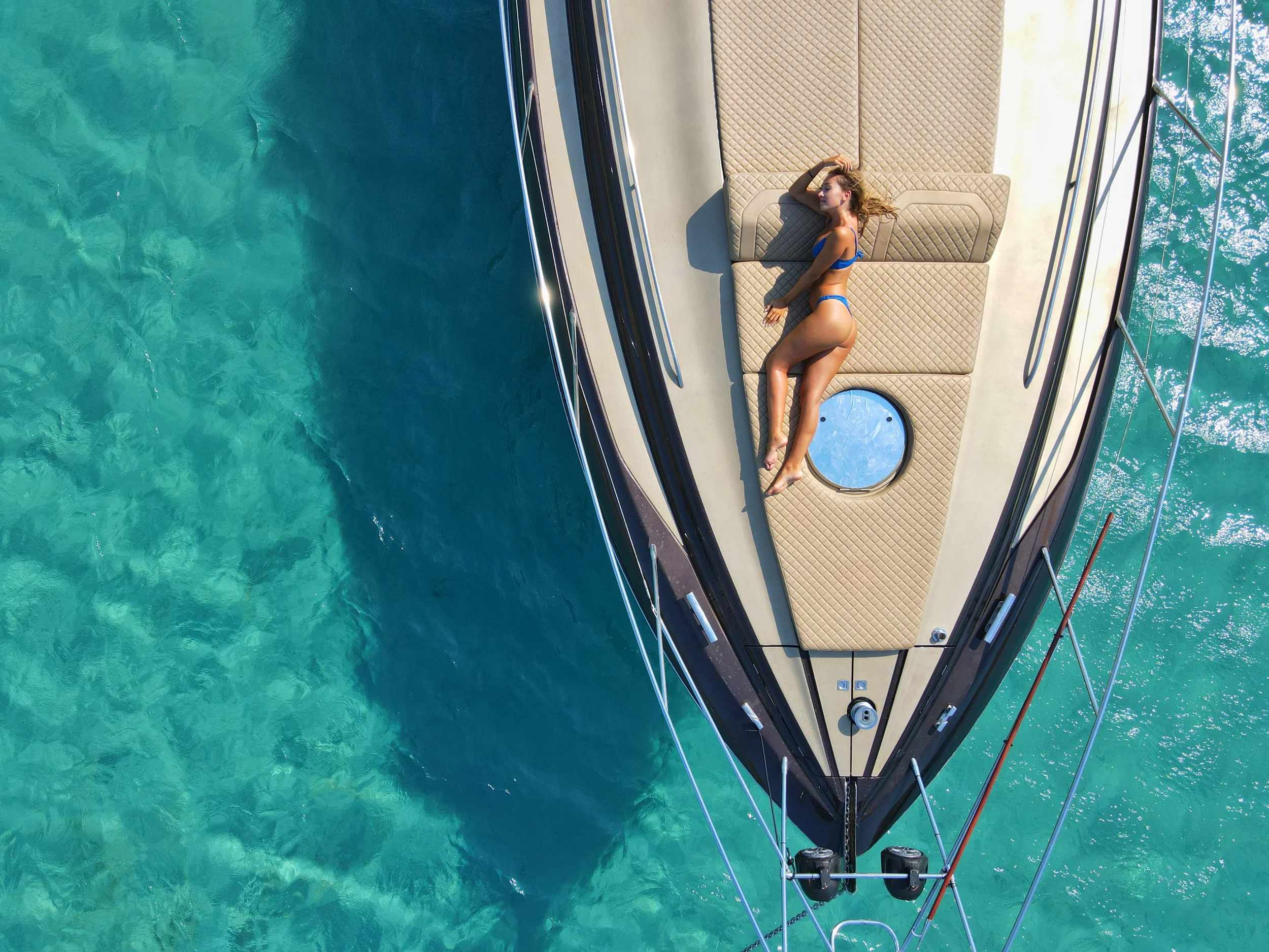 Aerial view of a yacht cruising through turquoise water