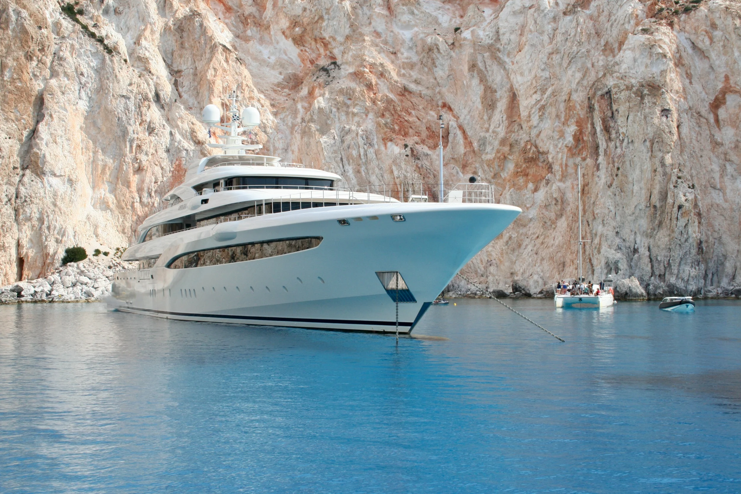 A yacht anchored in a calm bay at golden hour